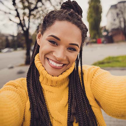 A woman smiling after receiving Invisalign treatment.