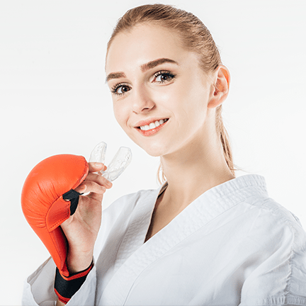 Combat sports player holding her soft mouth guard