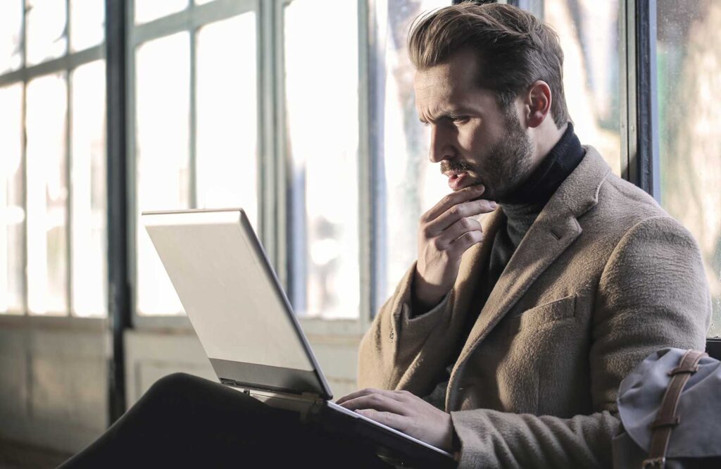 A man looking for answers to dental questions on a laptop.