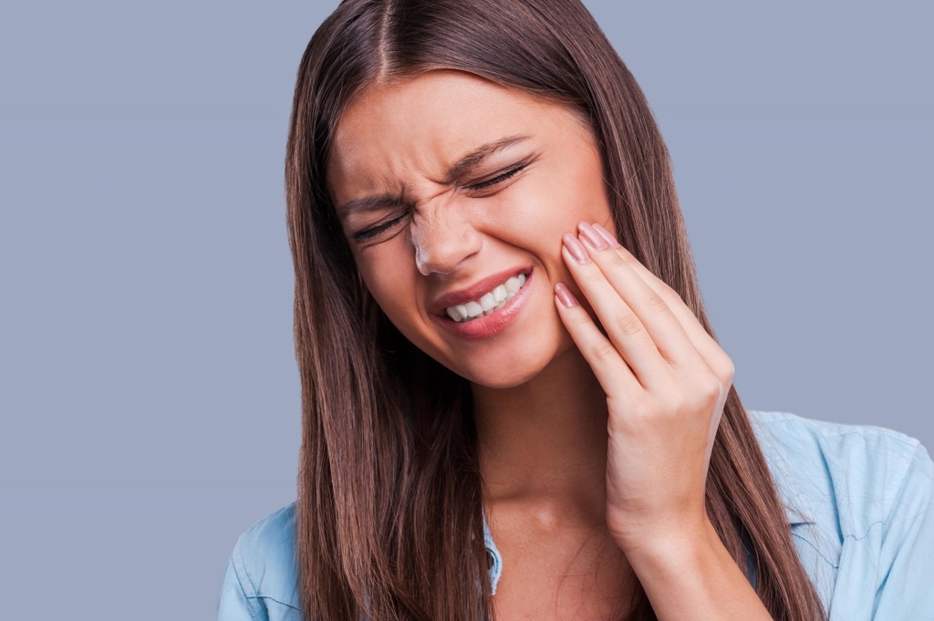 A patient in pain, caused by bad habits causing harm to your teeth and poor oral hygiene